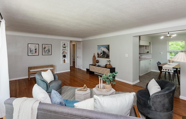 715 Maple St, Waukee, IA 50263 - living area featuring a textured ceiling, wood finished floors, and a chandelier