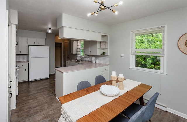 715 Maple St, Waukee, IA 50263 - dining area with a chandelier, dark wood-style floors, and a baseboard radiator
