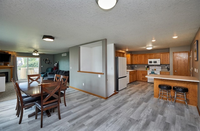 2014 Vista View Dr, Granger, IA 50109 - dining space with light wood-type flooring, a textured ceiling, a fireplace, ceiling fan, and recessed lighting