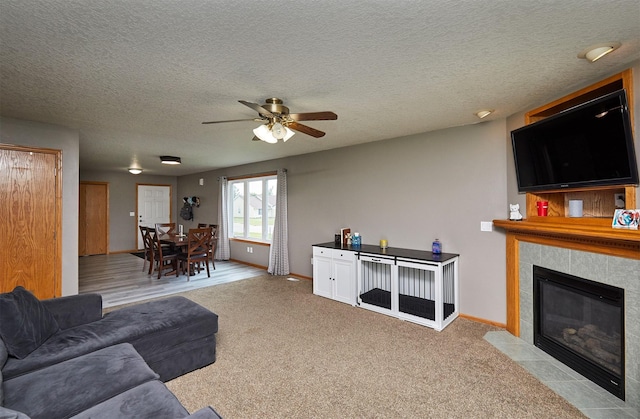 2014 Vista View Dr, Granger, IA 50109 - carpeted living room featuring ceiling fan, a tiled fireplace, and a textured ceiling