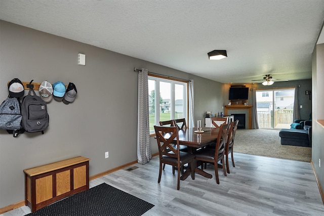 2014 Vista View Dr, Granger, IA 50109 - dining area featuring a fireplace, ceiling fan, light wood-type flooring, and a textured ceiling