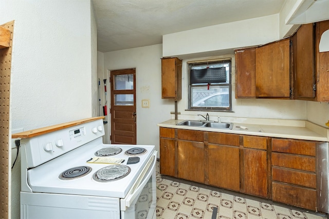 3120 Amherst St, Des Moines, IA 50313 - kitchen with white electric stove, light countertops, brown cabinets, and light floors