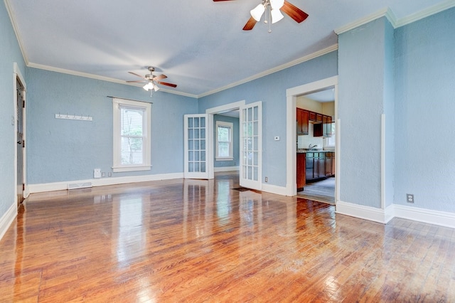 2736 College Ave, Des Moines, IA 50311 - spare room featuring ceiling fan, french doors, wood finished floors, and crown molding
