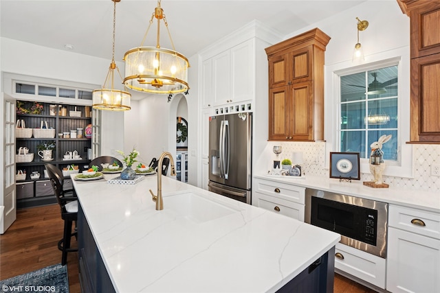 1811 SW Oak St, Ankeny, IA 50023 - kitchen with stainless steel refrigerator with ice dispenser, a chandelier, built in microwave, tasteful backsplash, and arched walkways