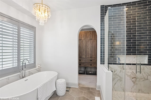 1811 SW Oak St, Ankeny, IA 50023 - full bathroom with a marble finish shower, a soaking tub, tile patterned floors, and a chandelier