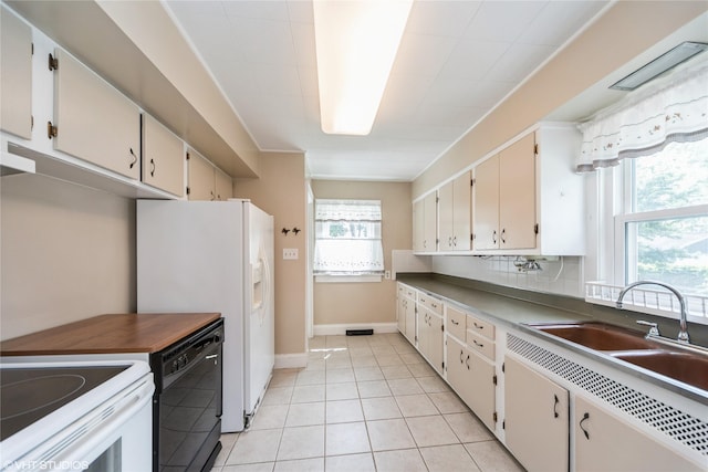 737 38th St, Des Moines, IA 50312 - kitchen featuring white appliances, healthy amount of natural light, and light tile patterned floors