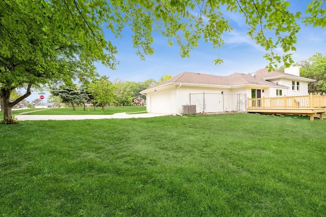 8501 NW Beaver Dr, Johnston, IA 50131 - view of grassy yard featuring a garage, concrete driveway, and a wooden deck