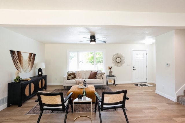 8501 NW Beaver Dr, Johnston, IA 50131 - living room featuring a ceiling fan, light wood finished floors, and stairway