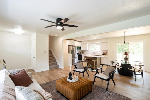 8501 NW Beaver Dr, Johnston, IA 50131 - living room with light wood-type flooring, stairs, a ceiling fan, and recessed lighting
