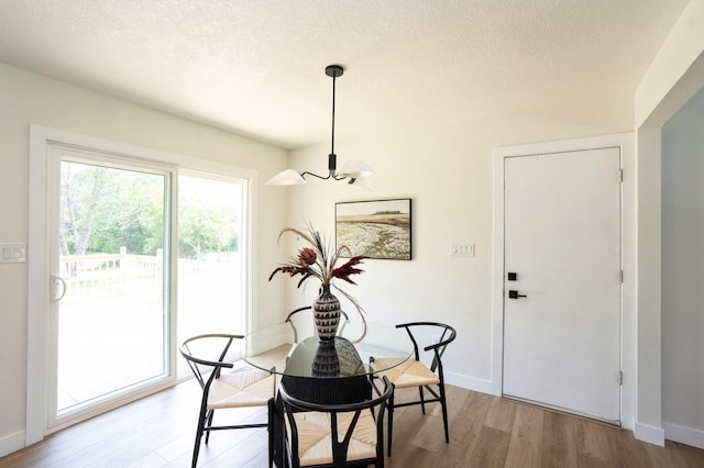 8501 NW Beaver Dr, Johnston, IA 50131 - dining space with a chandelier, wood finished floors, and a textured ceiling