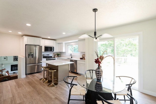 8501 NW Beaver Dr, Johnston, IA 50131 - dining area with a chandelier, light wood-style flooring, and recessed lighting
