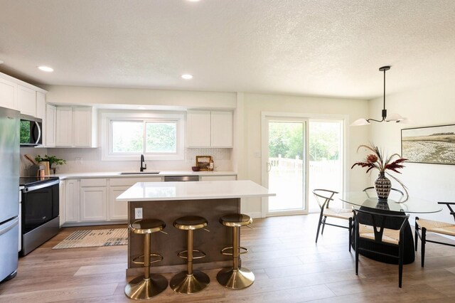 8501 NW Beaver Dr, Johnston, IA 50131 - kitchen with stainless steel appliances, a center island, light countertops, plenty of natural light, and recessed lighting