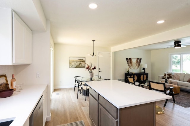 8501 NW Beaver Dr, Johnston, IA 50131 - kitchen featuring dishwasher, light wood finished floors, light countertops, a breakfast bar, and recessed lighting