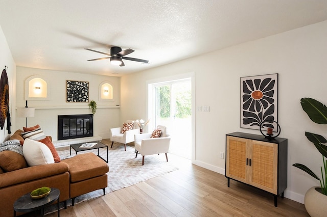 8501 NW Beaver Dr, Johnston, IA 50131 - living room with wood finished floors, a glass covered fireplace, and ceiling fan