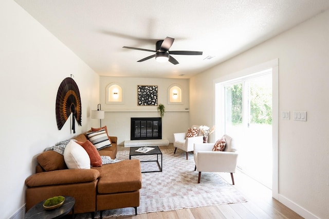 8501 NW Beaver Dr, Johnston, IA 50131 - living room with wood finished floors, a glass covered fireplace, and a ceiling fan