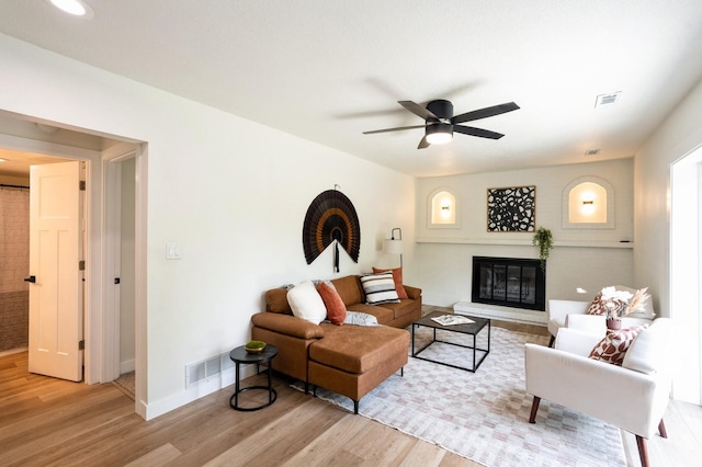 8501 NW Beaver Dr, Johnston, IA 50131 - living area with wood finished floors, ceiling fan, and a glass covered fireplace