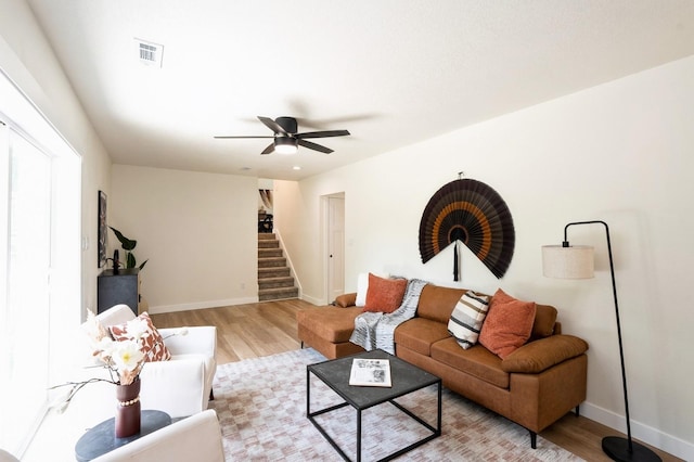 8501 NW Beaver Dr, Johnston, IA 50131 - living room with stairs, light wood-style floors, and ceiling fan