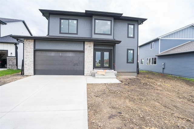 17987 Alpine Dr, Clive, IA 50325 - view of front facade featuring french doors, concrete driveway, stucco siding, and an attached garage