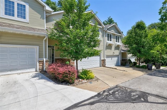 5583 Meredith Dr Unit 5C, Des Moines, IA 50310 - view of front of home with concrete driveway, an attached garage, and stone siding