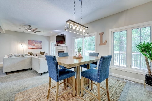 5583 Meredith Dr Unit 5C, Des Moines, IA 50310 - dining space with carpet flooring, plenty of natural light, a fireplace, and a ceiling fan