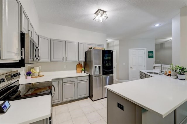 5583 Meredith Dr Unit 5C, Des Moines, IA 50310 - kitchen featuring appliances with stainless steel finishes, gray cabinetry, light countertops, a textured ceiling, and recessed lighting