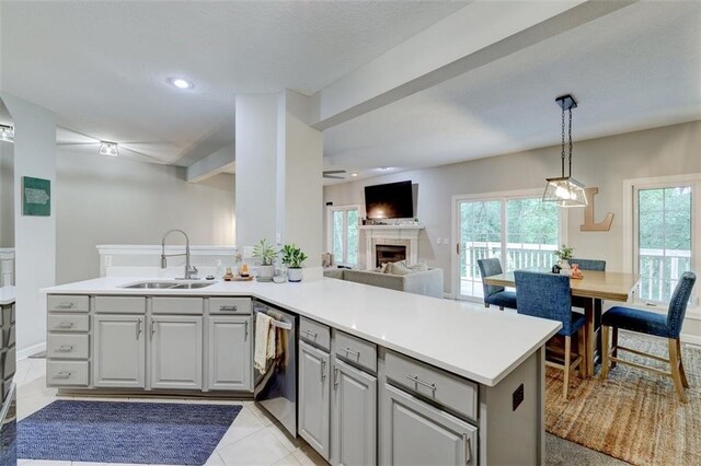 5583 Meredith Dr Unit 5C, Des Moines, IA 50310 - kitchen with a peninsula, dishwasher, open floor plan, a tile fireplace, and light countertops