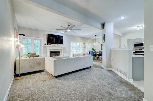 5583 Meredith Dr Unit 5C, Des Moines, IA 50310 - living area with light carpet, a glass covered fireplace, ceiling fan, beamed ceiling, and recessed lighting