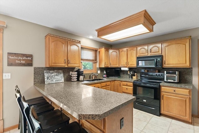 1305 NW Wagner Blvd, Ankeny, IA 50023 - kitchen with black appliances, a peninsula, decorative backsplash, and a breakfast bar area