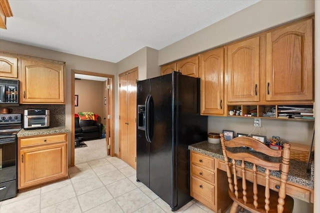 1305 NW Wagner Blvd, Ankeny, IA 50023 - kitchen featuring black appliances, built in desk, light tile patterned floors, and dark stone countertops