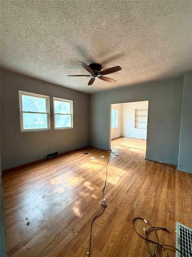 2216 Logan Ave, Des Moines, IA 50317 - unfurnished room with healthy amount of natural light, ceiling fan, a textured ceiling, and wood finished floors