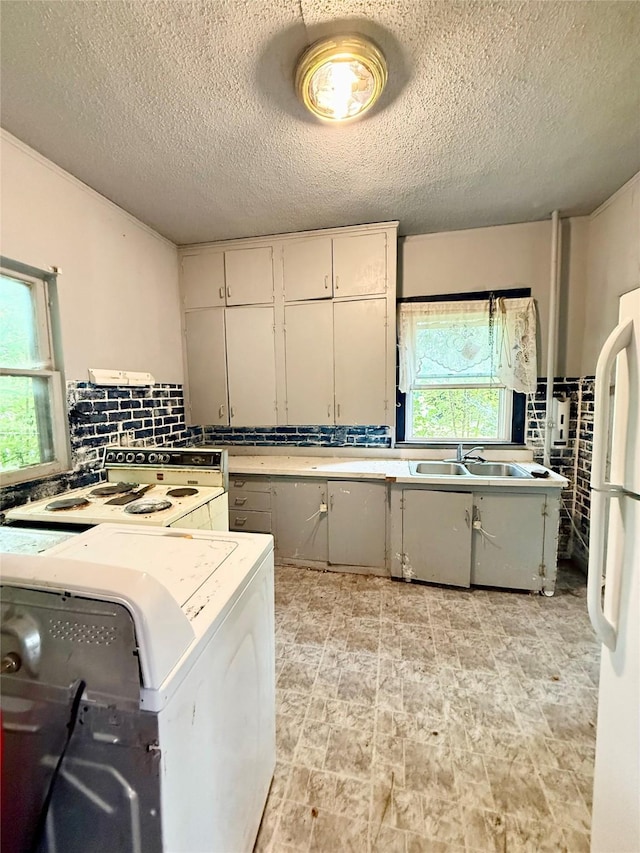 2216 Logan Ave, Des Moines, IA 50317 - washroom featuring a textured ceiling and washer / clothes dryer
