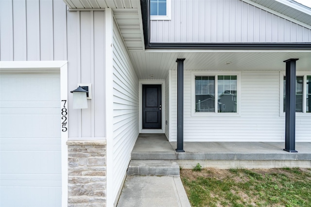 7825 SE 2nd St, Des Moines, IA 50320 - doorway to property with covered porch and board and batten siding