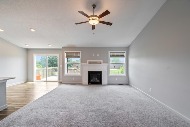 7825 SE 2nd St, Des Moines, IA 50320 - unfurnished living room with a ceiling fan, a glass covered fireplace, carpet, wood finished floors, and recessed lighting