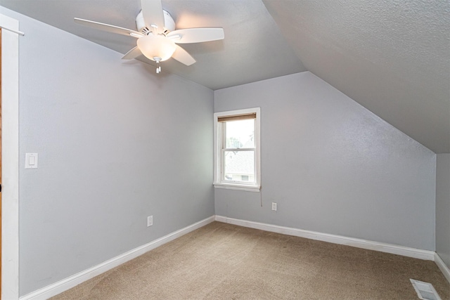 1229 9th St, Nevada, IA 50201 - additional living space featuring vaulted ceiling, carpet, ceiling fan, and a textured ceiling