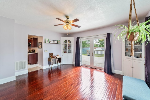2800 E Douglas Ave, Des Moines, IA 50317 - unfurnished living room with french doors, ceiling fan, wood finished floors, and a textured ceiling