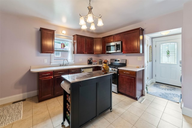2800 E Douglas Ave, Des Moines, IA 50317 - kitchen featuring appliances with stainless steel finishes, a chandelier, pendant lighting, a center island, and light tile patterned floors