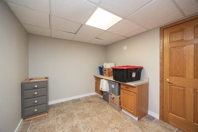 905 SE Meadowlark Dr, Grimes, IA 50111 - kitchen with a paneled ceiling, light countertops, light stone finish floors, and brown cabinetry