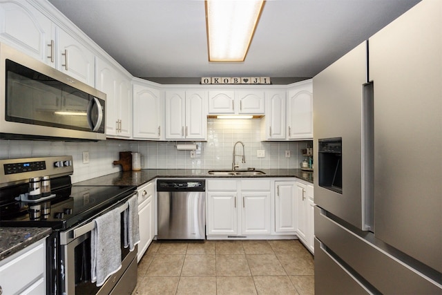905 SE Meadowlark Dr, Grimes, IA 50111 - kitchen featuring appliances with stainless steel finishes, white cabinetry, decorative backsplash, and light tile patterned floors