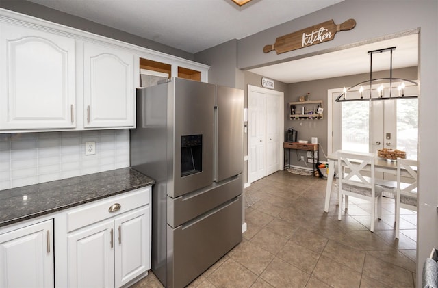 905 SE Meadowlark Dr, Grimes, IA 50111 - kitchen featuring stainless steel refrigerator with ice dispenser, white cabinetry, dark stone counters, light tile patterned floors, and a chandelier