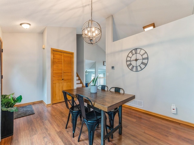 2015 NW 158th St, Clive, IA 50325 - dining space with stairs, wood finished floors, a chandelier, and high vaulted ceiling