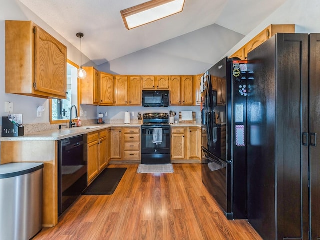 2015 NW 158th St, Clive, IA 50325 - kitchen featuring black appliances, vaulted ceiling, light wood finished floors, light countertops, and decorative light fixtures
