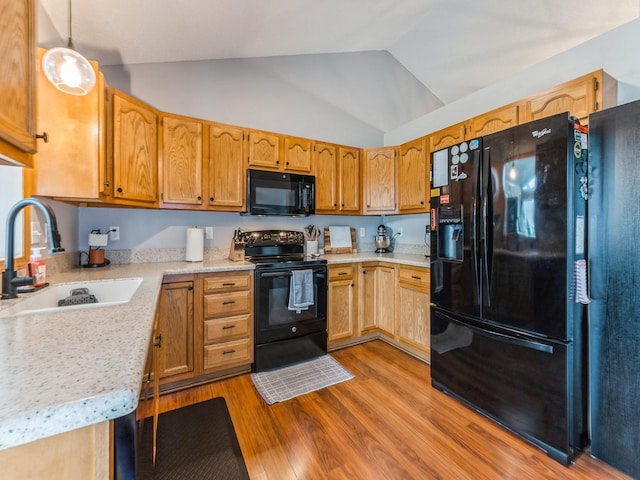 2015 NW 158th St, Clive, IA 50325 - kitchen featuring black appliances, wood finished floors, light countertops, lofted ceiling, and pendant lighting
