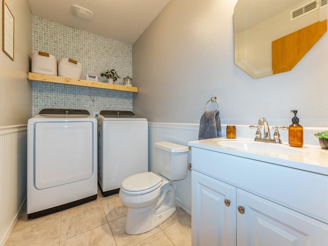 2015 NW 158th St, Clive, IA 50325 - half bath with washer and clothes dryer, a wainscoted wall, vanity, and tile patterned floors