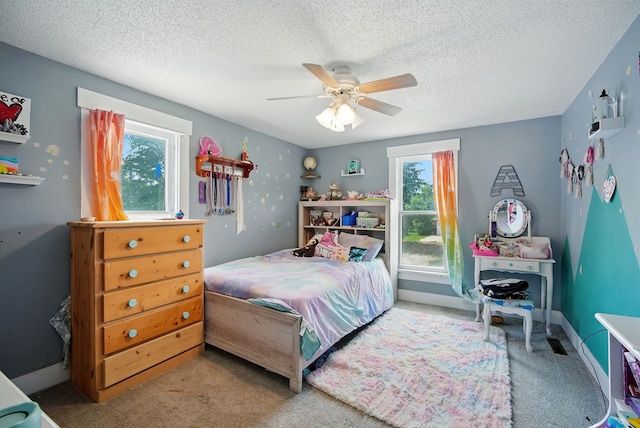 455 NW 2nd St, Earlham, IA 50072 - bedroom with multiple windows, carpet flooring, ceiling fan, and a textured ceiling