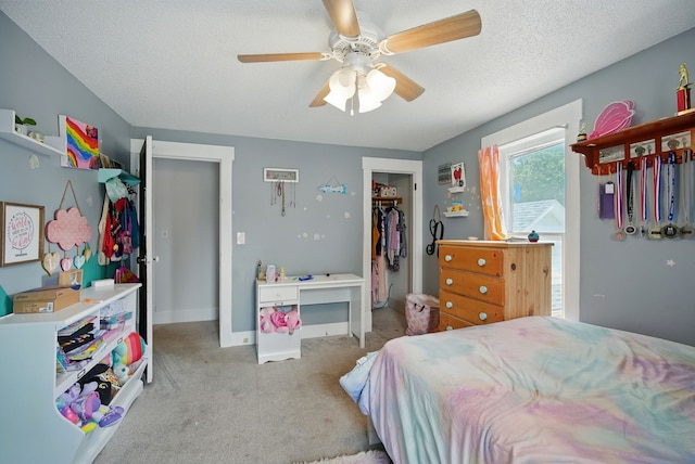 455 NW 2nd St, Earlham, IA 50072 - bedroom with carpet, a spacious closet, a textured ceiling, ceiling fan, and a closet