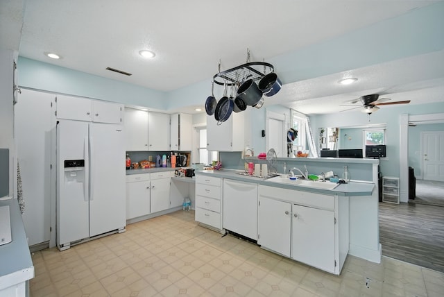 455 NW 2nd St, Earlham, IA 50072 - kitchen with white appliances, a peninsula, light floors, white cabinetry, and recessed lighting