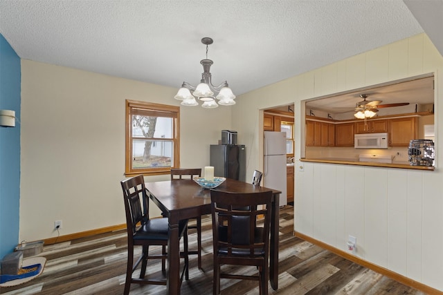 102 Kellogg Ave, Dallas Center, IA 50063 - dining area with dark wood finished floors, a chandelier, a textured ceiling, and ceiling fan