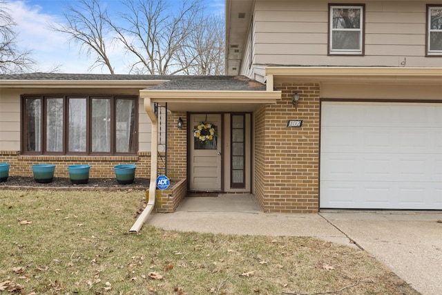 102 Kellogg Ave, Dallas Center, IA 50063 - property entrance featuring an attached garage, brick siding, and driveway
