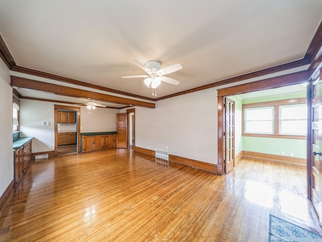 3324 Rollins Ave, Des Moines, IA 50312 - unfurnished living room featuring a ceiling fan, light wood-type flooring, ornamental molding, and wainscoting