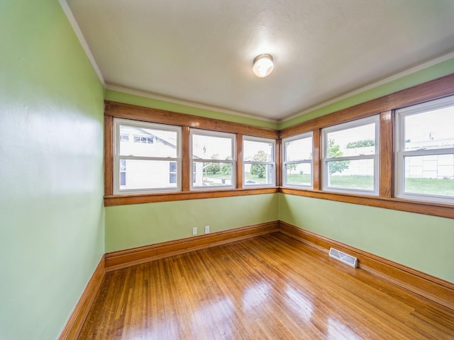 3324 Rollins Ave, Des Moines, IA 50312 - unfurnished room with plenty of natural light, hardwood / wood-style floors, and crown molding